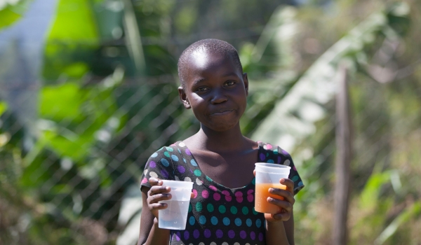 Girl showcases harvested river water and filtered water sold at kiosk (Karim photography(c)2020)